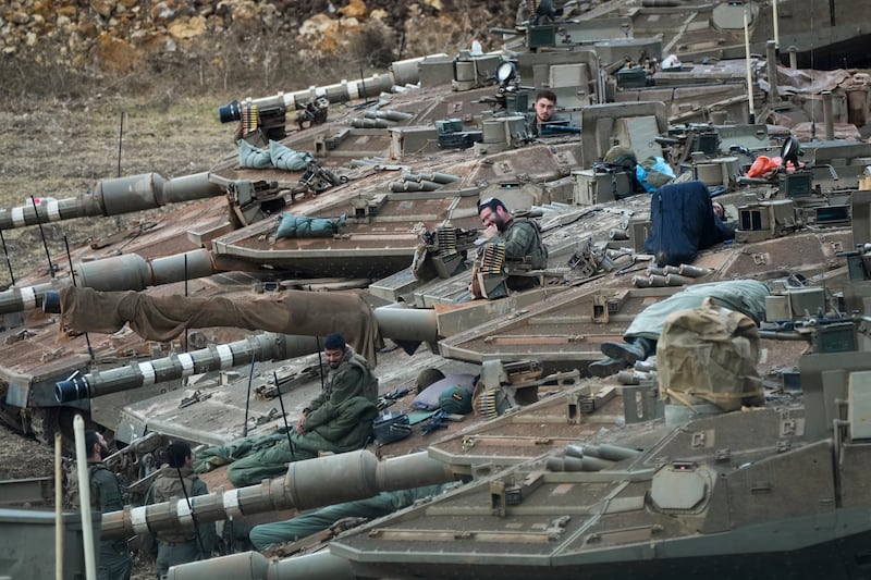 Israeli soldiers work on tanks in a staging area in northern Israel near the Lebanon border (Baz Ratner/AP)