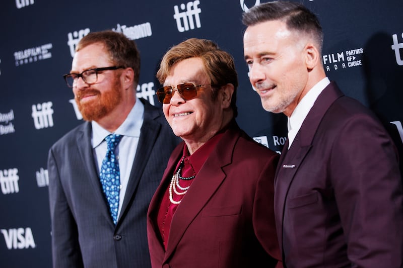 RJ Cutler, left, Sir Elton John and David Furnish arrive on the red carpet for the premiere of Elton John: Never Too Late (Cole Burston/The Canadian Press via AP)