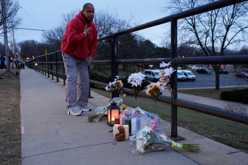 A person who did not wish to give his name places flowers outside the Abundant Life Christian School (Nam Y Huh/AP)