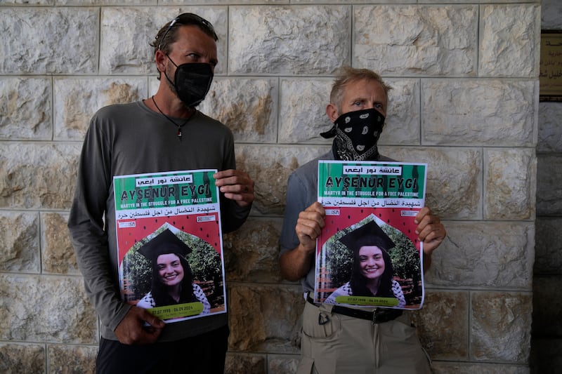 Activist colleagues of Aysenur Ezgi Eygi hold posters with her name and photo during her funeral in the West Bank city of Nablus on Monday (Nasser Nasser/AP)