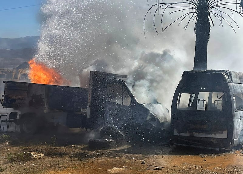 A lorry and ambulance burn after Israeli airstrikes hit a group of paramedics outside a hospital in Marjayoun, south Lebanon (AP)