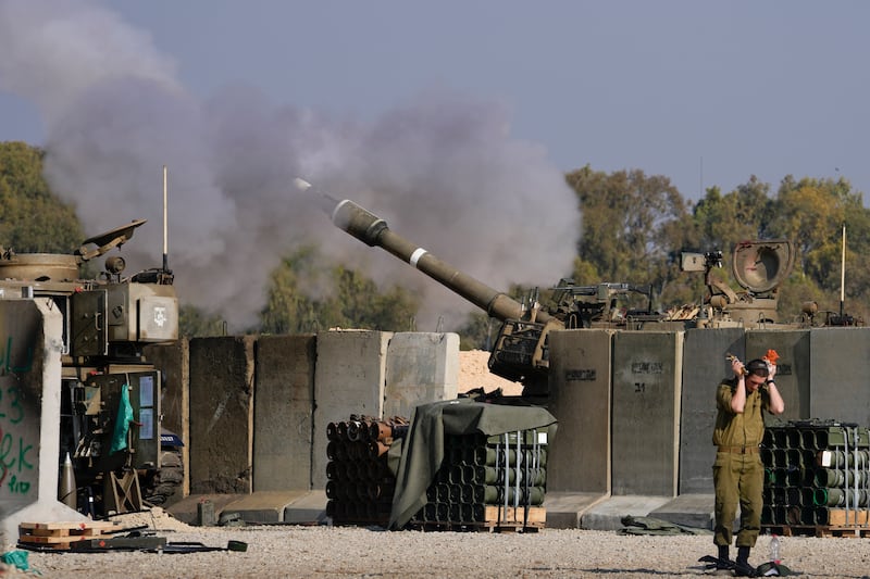 An Israeli soldier covers his ears as an artillery gunner fires into the Gaza Strip from a position in southern Israel on Thursday (Matias Delacroix/AP)