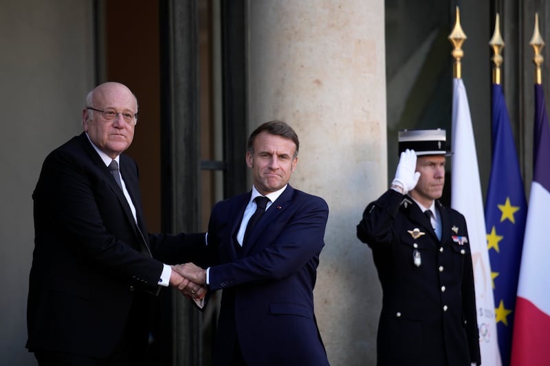 French President Emmanuel Macron welcomes Lebanese caretaker Prime Minister Najib Mikati (Louise Delmotte/AP)