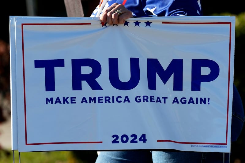 A supporter of Republican presidential nominee former President Donald Trump, carries a sign (Nam Y Huh/AP)