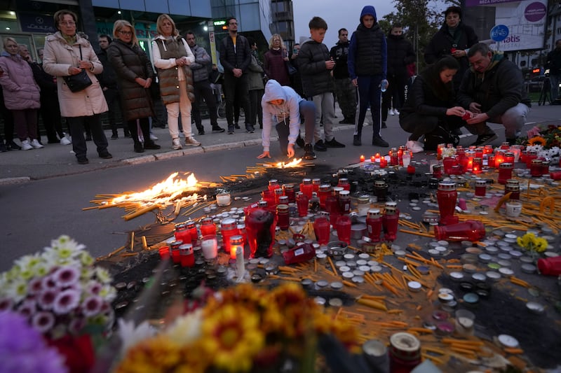 People light candles for the victims of an outdoor roof collapse at a train station in Novi Sad, Serbia (AP Photo/Darko Vojinovic)