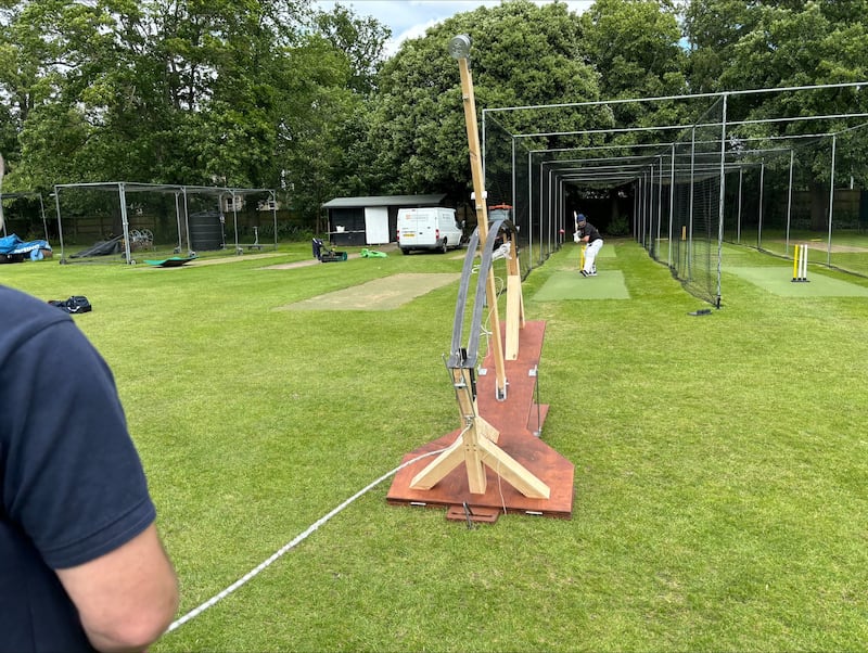 The Venn bowling machine launches a ball at a batter in the nets.