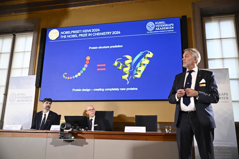 Johan Aqvist, right, of the Nobel Committee for Chemistry, explains the work of this year’s prize winners, David Baker, Demis Hassabi and John Jumper (Christine Olsson/AP)