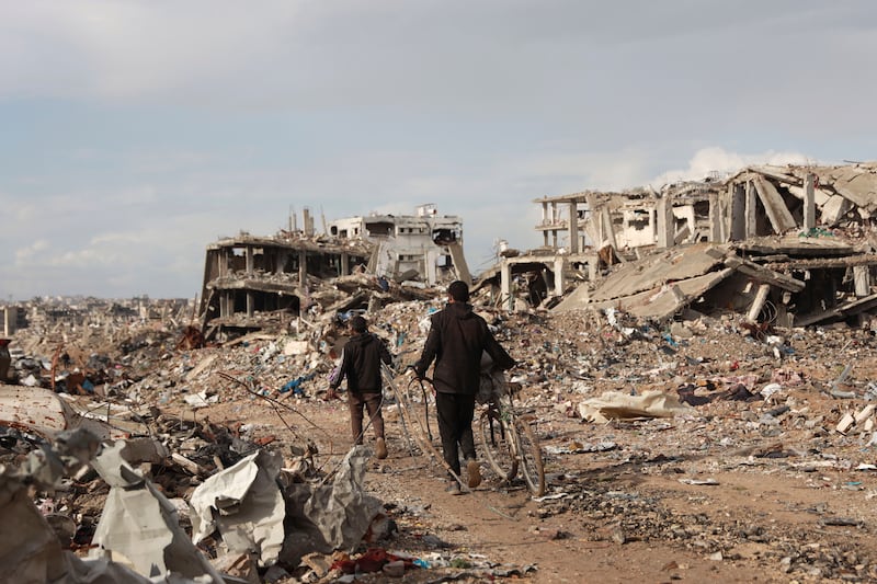 Palestinians walk on the rubble of destroyed houses after the ceasefire deal between Israel and Hamas in Gaza (Abed Hajjar/AP)