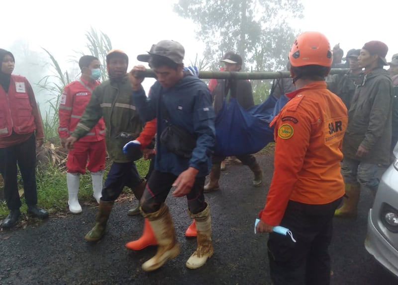 Rescuers carry the body of a victim of flash flooding in Pekalongan, Central Java, Indonesia (BNPB/AP)