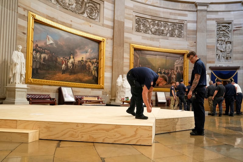 Workers build a stage in the US Capitol Rotunda for the 60th presidential inauguration which was moved indoors because of expected cold temperatures (Morry Gash/AP)