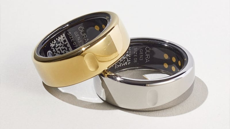 A photo of two Oura Ring fitness trackers, in gold and silver