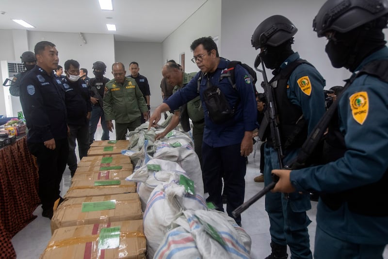 An Indonesian environment ministry official inspects sacks and boxes containing pangolin scales confiscated from suspected smugglers in Medan, North Sumatra (Binsar Bakkara/AP)