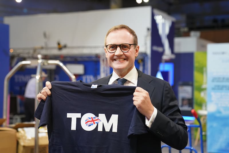 Tom Tugendhat looking at one of his T-shirts during the Conservative Party Conference