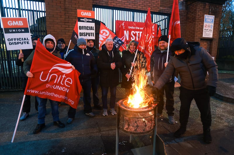 Translink workers on the picket line at the Europa Bus Centre in Belfast gathered around a fire to keep warm as thousands of public sector workers begin a strike. PICTURE: MAL MCCANN