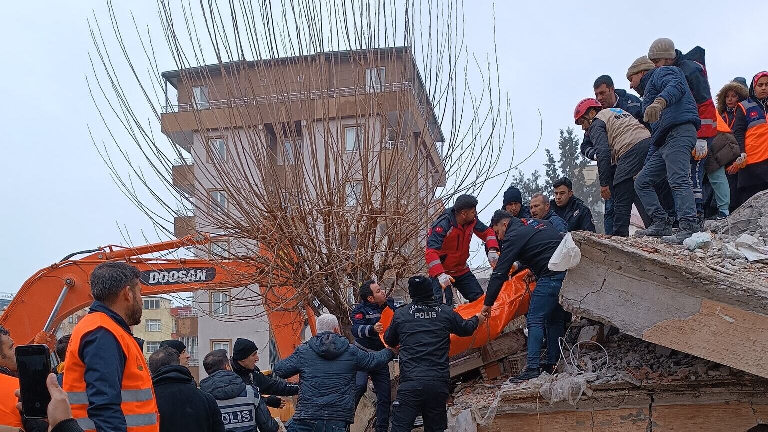 Photo taken with permission from the Twitter account @mehmetyetim63 of police and volunteers removing a body from a collapsed building in Sanliurfa, Turkey, following an earthquake 