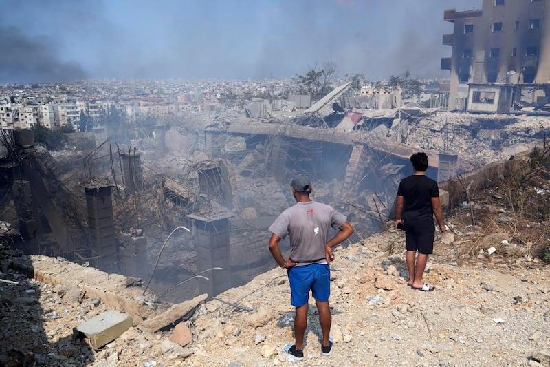 People check a damaged building at the site of an Israeli airstrike in Choueifat, south east of Beirut (Hussein Malla/AP)