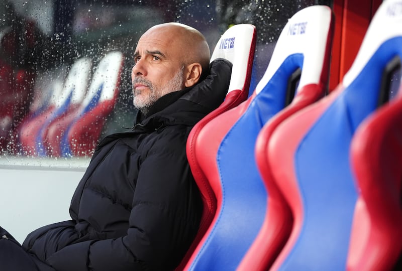 Pep Guardiola sits on the touchline at Selhurst Park