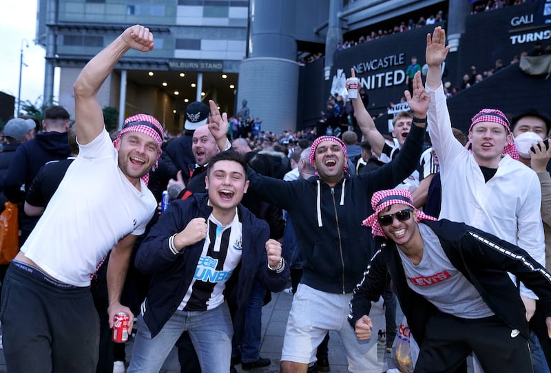 Newcastle fans celebrate the Saudi-led takeover of the club in October 2021