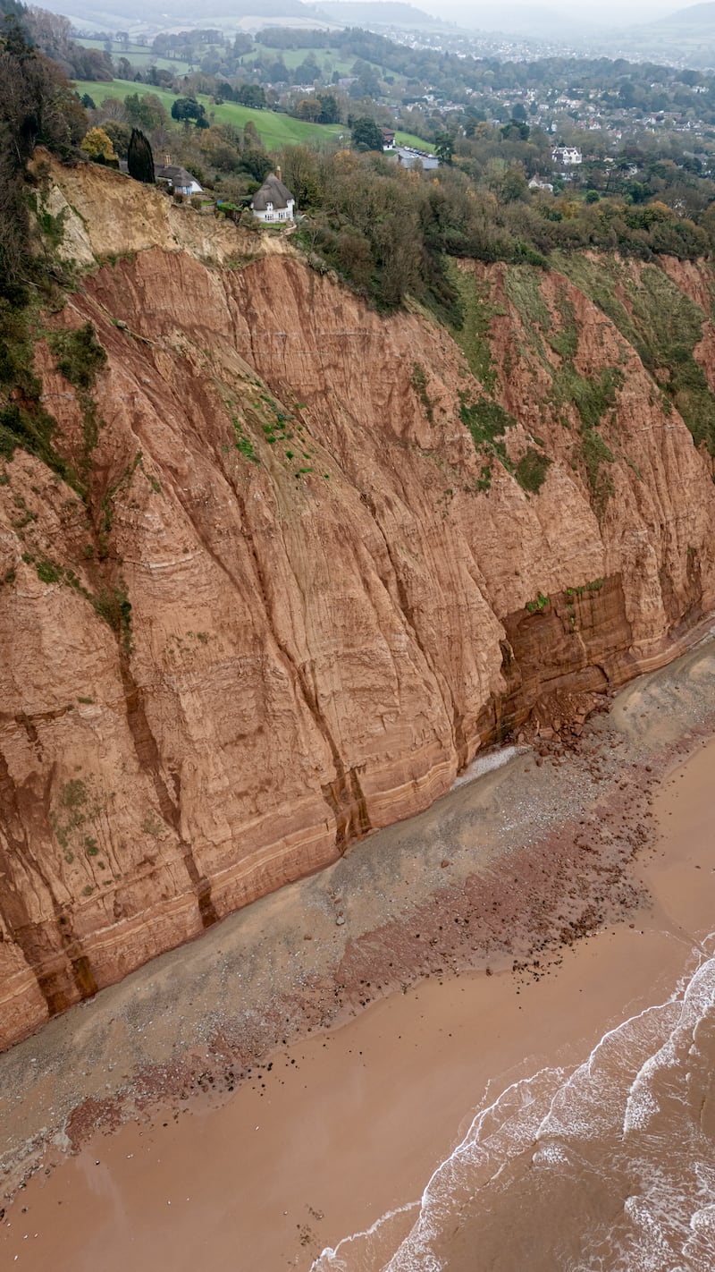 The cottage is now perched above a 400ft drop, following a rockfall (seen as the dark angular shape below) on a cliff top area between Sidmouth and Ladram Bay