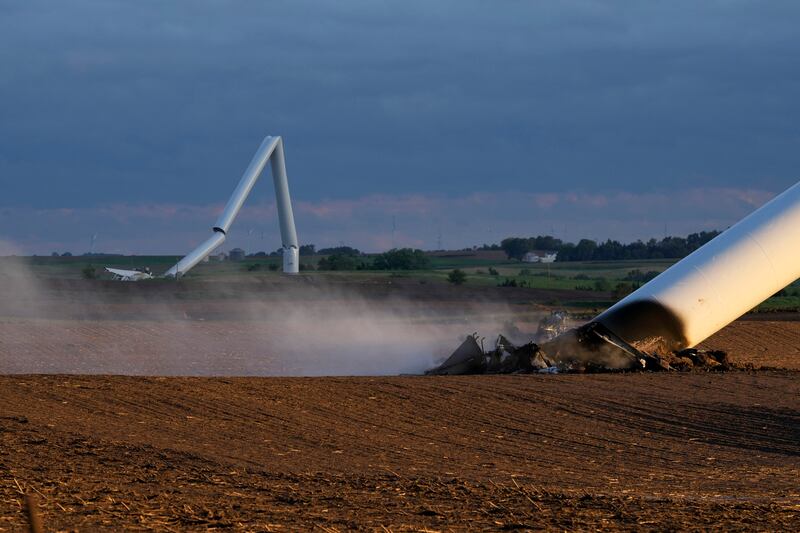 The remains of two tornado-damaged wind turbines touch the ground in a field near Prescott, Iowa (Charlie Neibergall/AP)