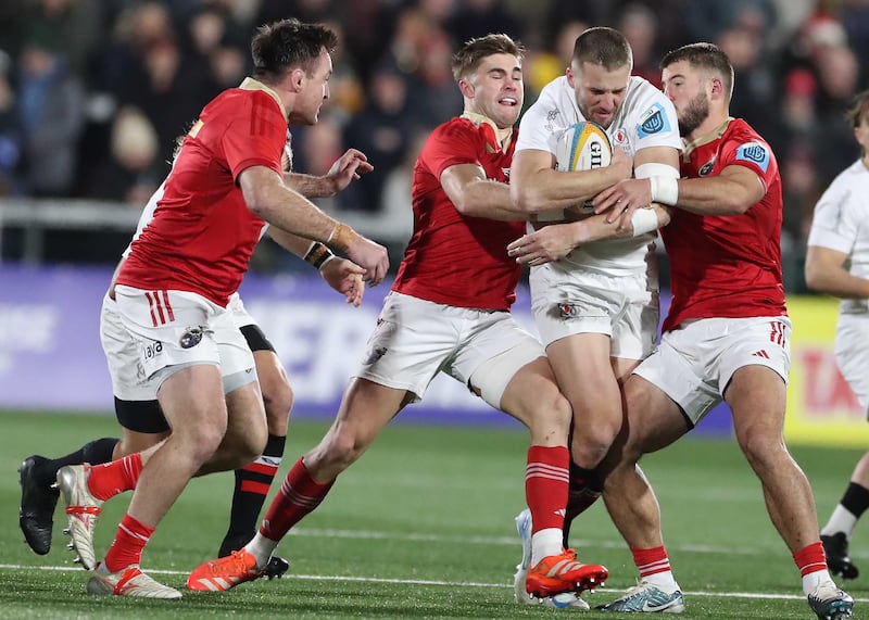 Ulster Rugby's Stuart McCloskey tackled by Munster's Jack Crowley and Alex Nankivell  at Kingspan Stadium