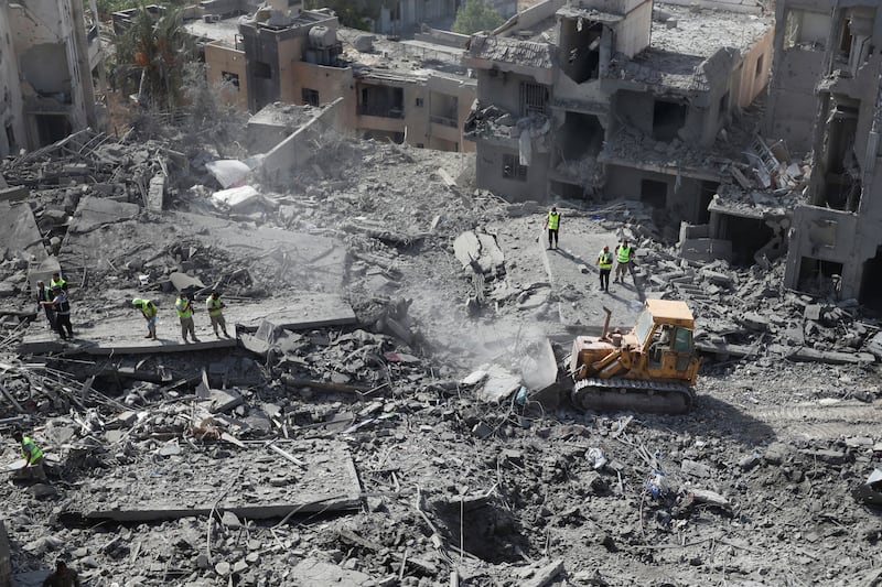 Rescue workers use a bulldozer to remove rubble of destroyed buildings at the site that was hit by Israeli airstrikes in Qana village (Mohammed Zaatari/AP)