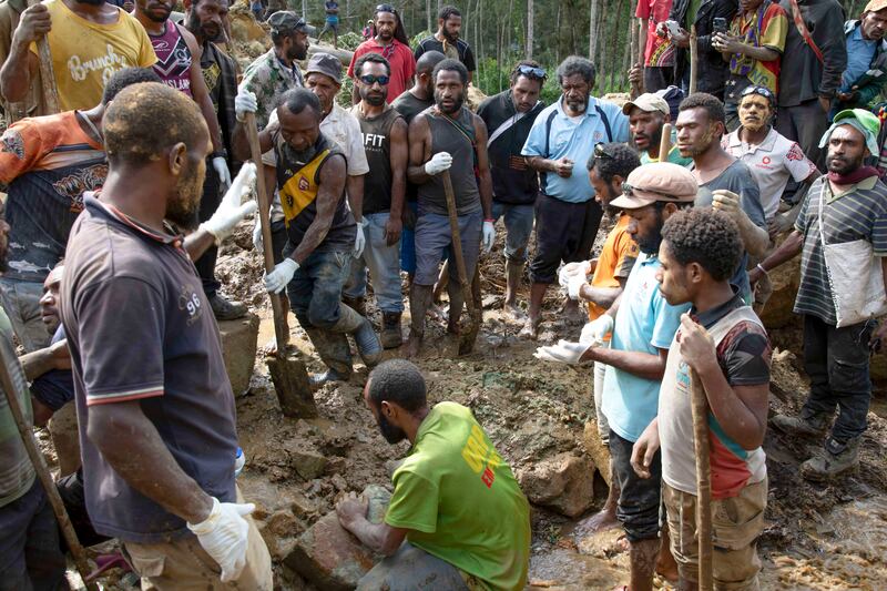 Villagers search through a landslide in Yambali in the highlands of Papua New Guinea (Juho Valta/AP)