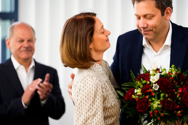 SPD co-chairman Lars Klingbeil, right, gives flowers to top candidate Katarina Barley, centre (AP)