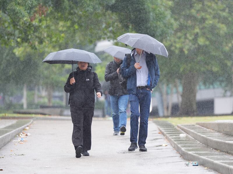 People walking in wet and windy conditions brought by the storm near Tower Bridge, central London