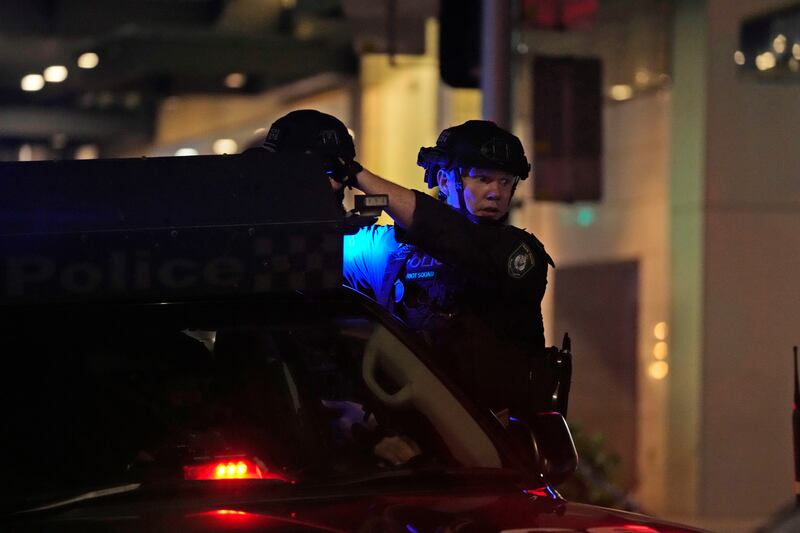 Tactical police leave the shopping centre (Rick Rycroft/AP)