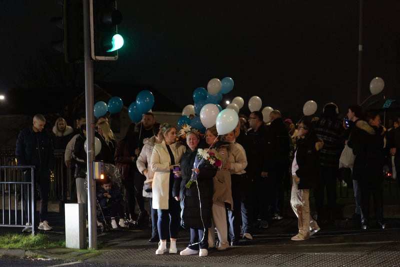 People attend a vigil at the scene in Blanchardstown Road North on Friday night