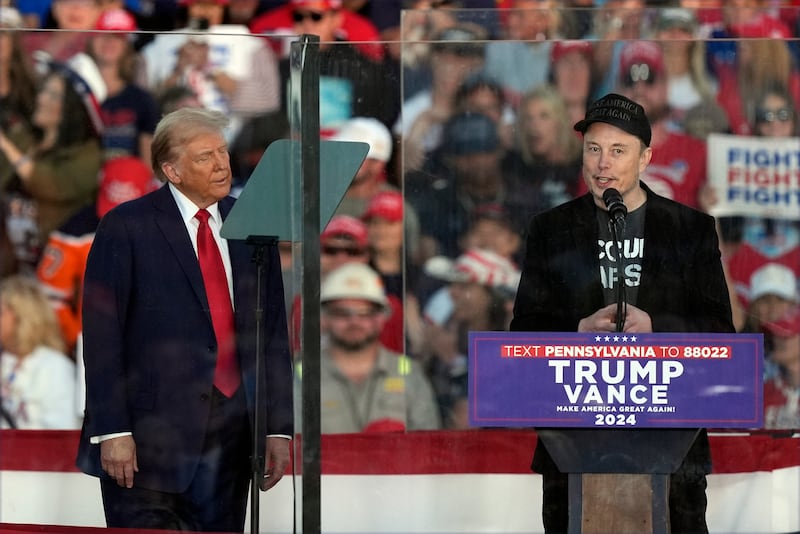 Donald Trump listens as Elon Musk speaks during a campaign rally (Julia Demaree Nikhinson/AP)