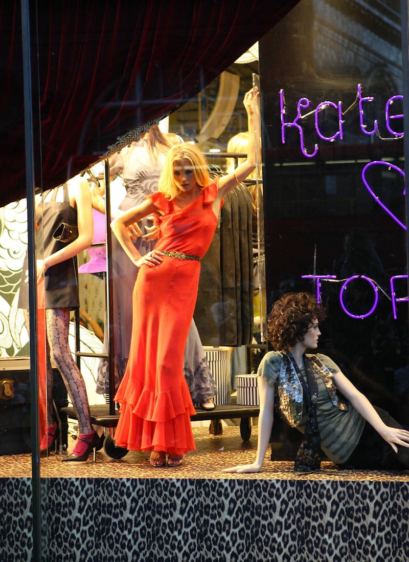 Moss posed in the shop window alongside the mannequins wearing her collection