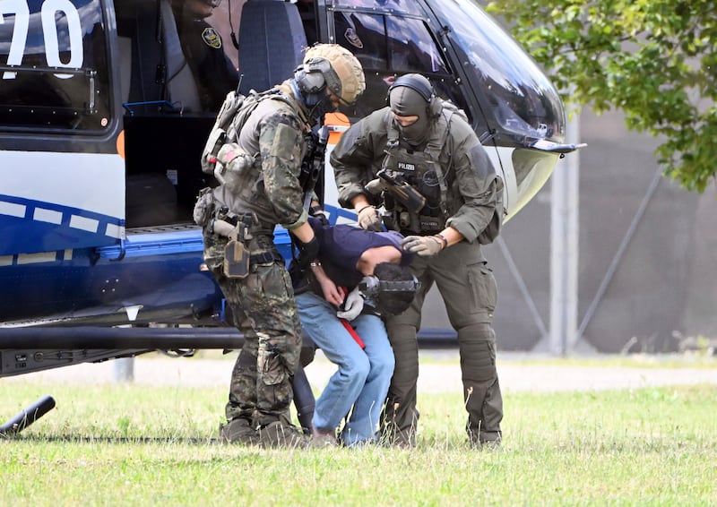 The Solingen knife attack suspect is escorted from a helicopter in Karlsruhe (Uli Deck/dpa/AP)