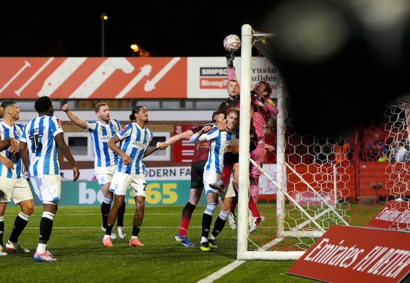 Chris Maxwell punches the ball into his own net