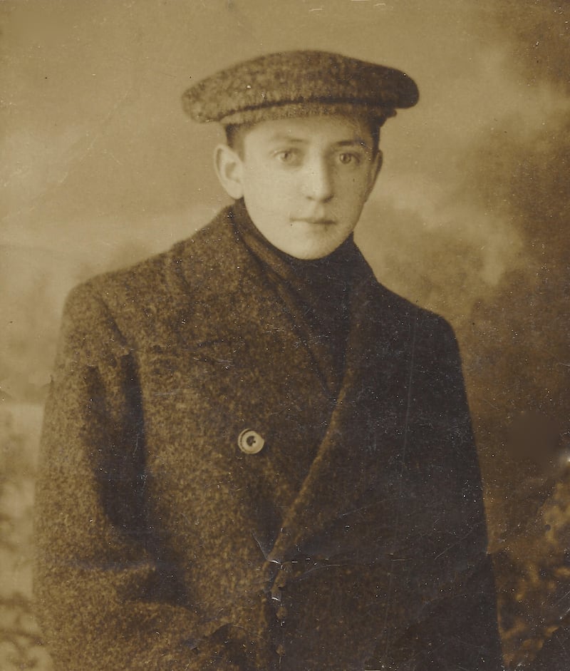 Old portrait of a young boy standing in front of the camera.