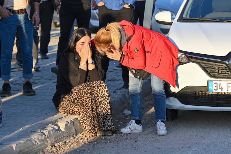 People gather outside of Turkish Aerospace Industries Inc on the outskirts of Ankara (AP)