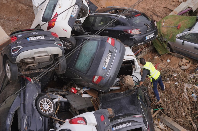 A civil guard searches for survivors in cars (Alberto Saiz/AP)