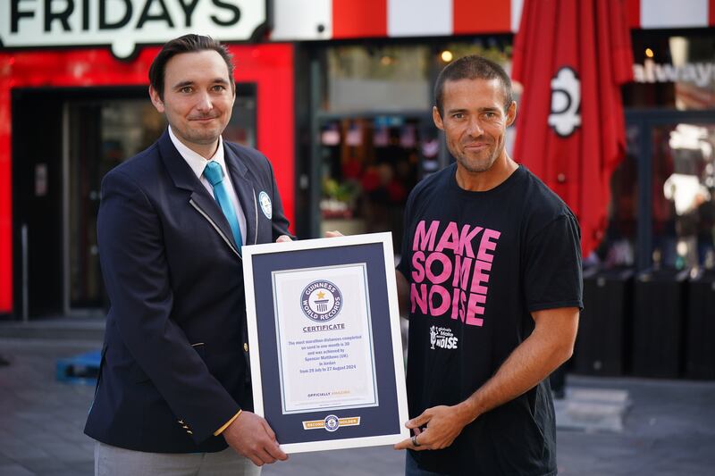 Guinness World Record adjudicator Will Munford presents Matthews with his Guinness World Record certificate