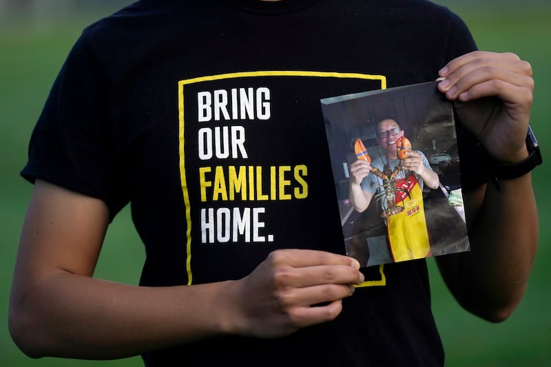 Harrison Li holds a photo of his father, Kai Li (Jeff Chiu/AP)