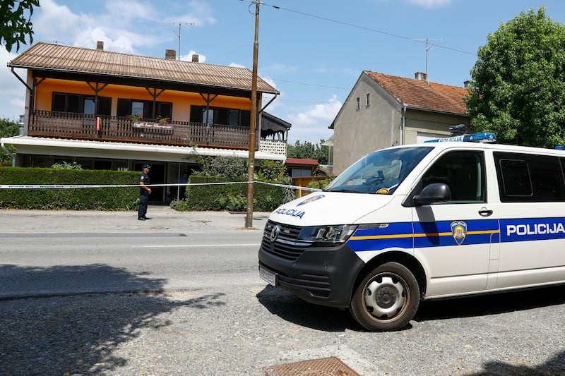 A police officer stands outside the cafe where the shooter was arrested in Daruva (Zeljko Puhovski/Cropix/AP)