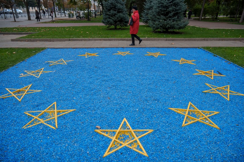 A woman walks by a depiction of the European Union flag near a park in central Chisinau Moldova (Vadim Ghirda/AP)