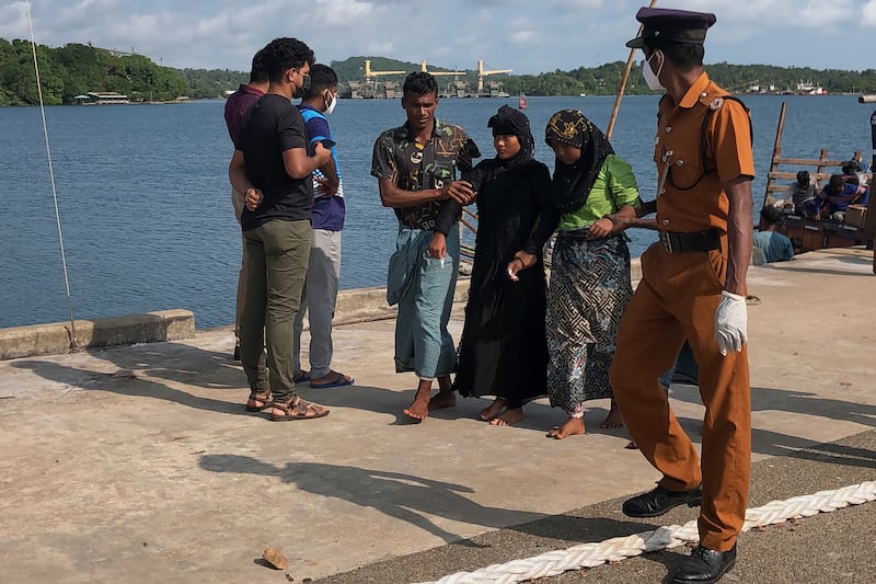 Two women and a man, believed to be Rohingya refugees, arrive at a port in Trincomalee, Sri Lanka (Mangalanath Liyanaarahhi/AP)