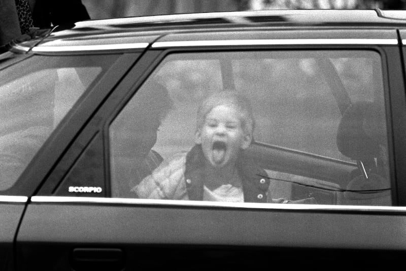 A three-year-old Prince Harry sticks out his tongue at photographers