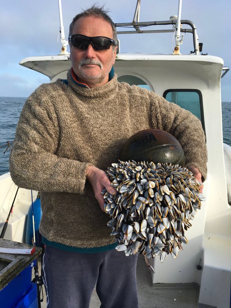 Annie's husband Ian holds the basketball covered in goose barnacles
