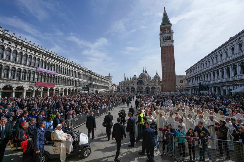 St Mark’s Square was packed as the Pope, bottom left, arrived for Mass (Alessandra Tarantino/AP)