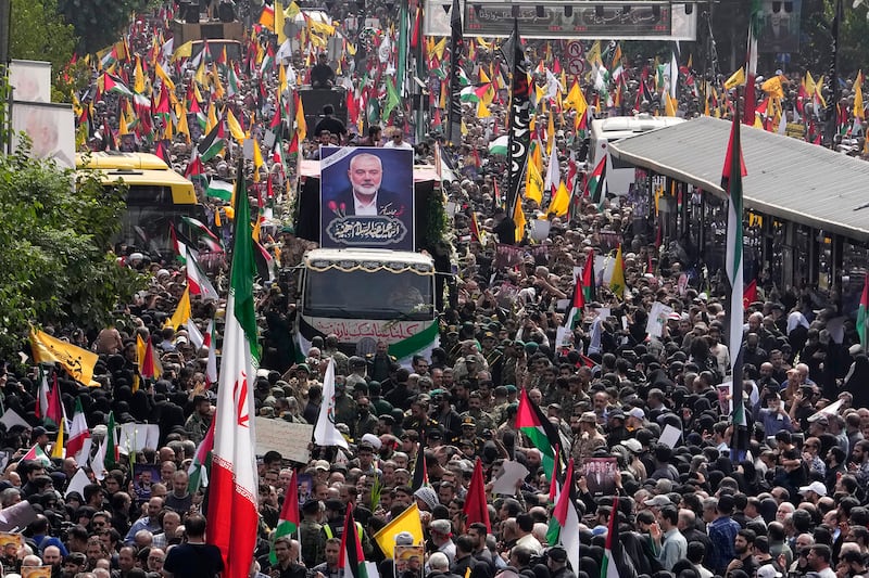 Iranians follow a truck carrying the coffins of Hamas leader Ismail Haniyeh and his bodyguard in Tehran (Vahid Salemi/AP)