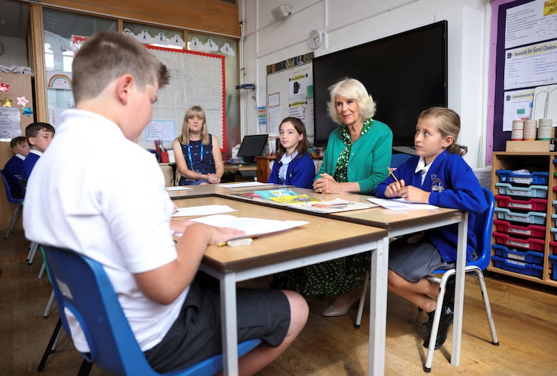 The Queen listens as a pupil reads a poem they have written