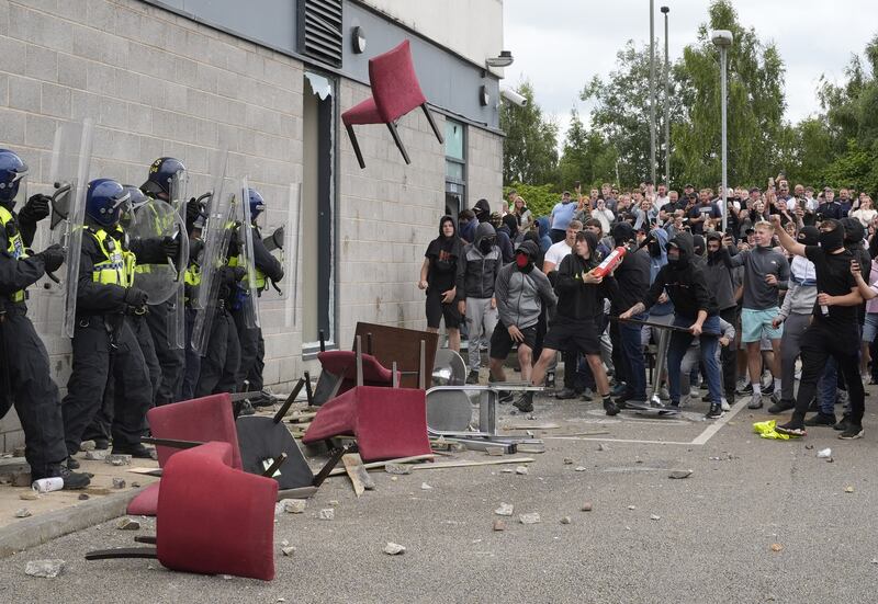 A chair is launched at police officers outside the Holiday Inn Express in Rotherham