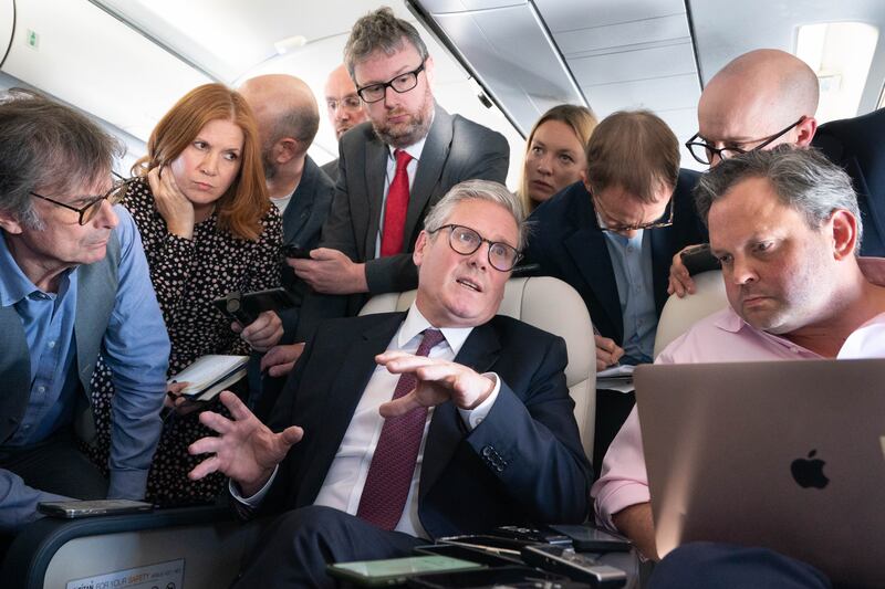 Sir Keir Starmer talks to the media on board his plane as he flies to Washington DC